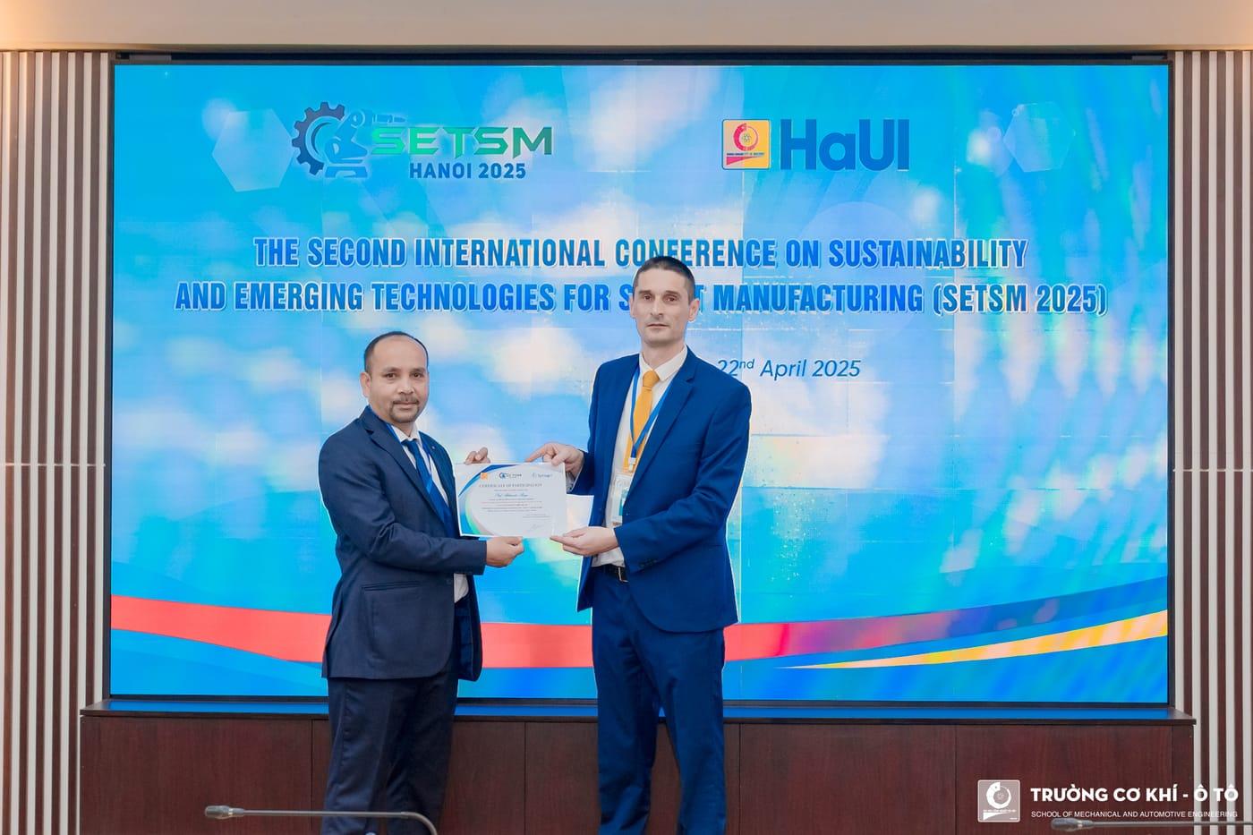 A certificate presented to a speaker in front of the conference backdrop