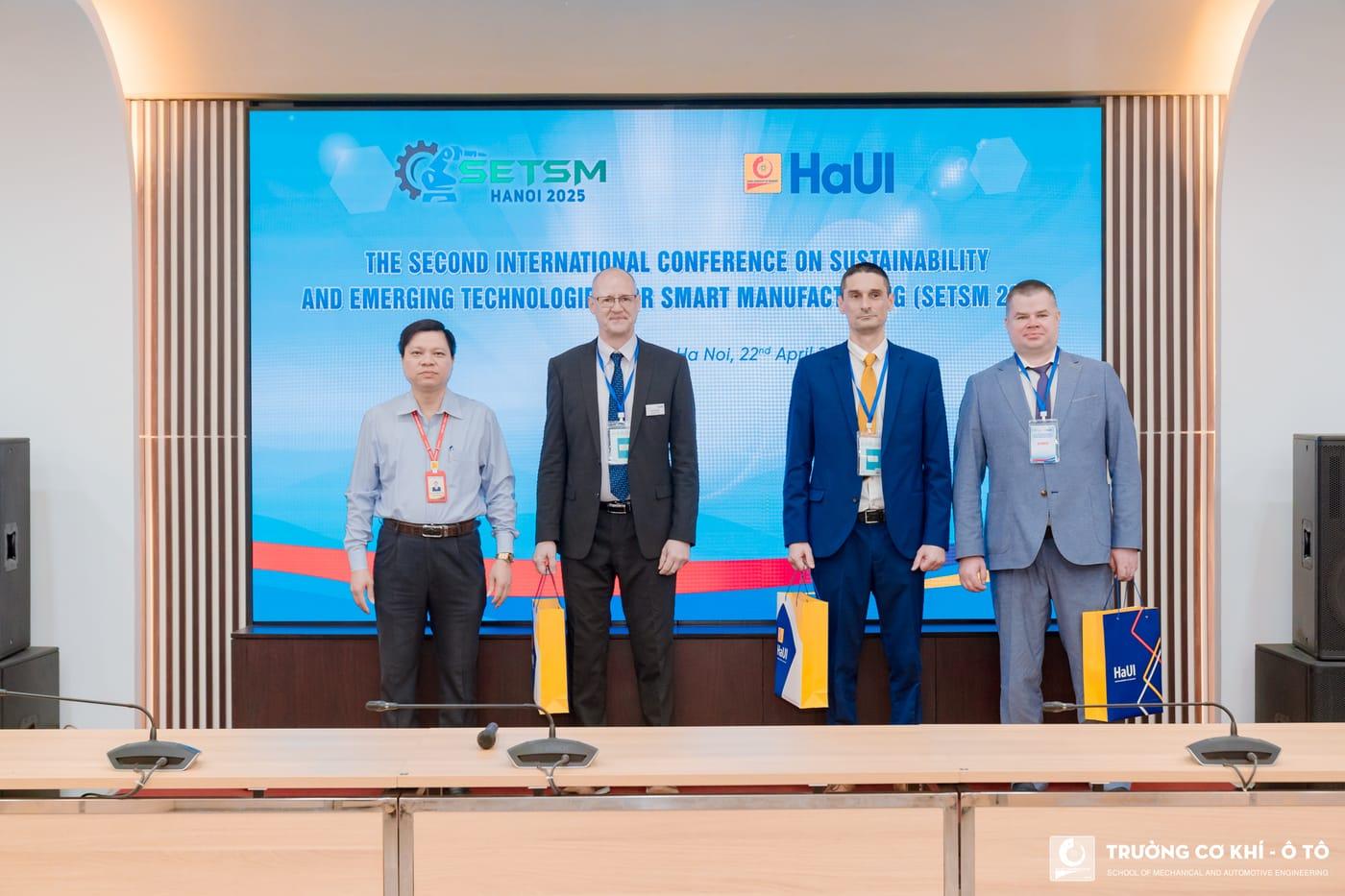 Speakers on stage beneath the conference backdrop